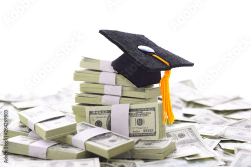 Tablou pe pânză Mortarboard on a pile of money representing the high cost of higher education an