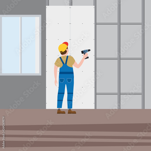 Professional worker man installing gypsum plasterboard panels with a screwdriver in the interior