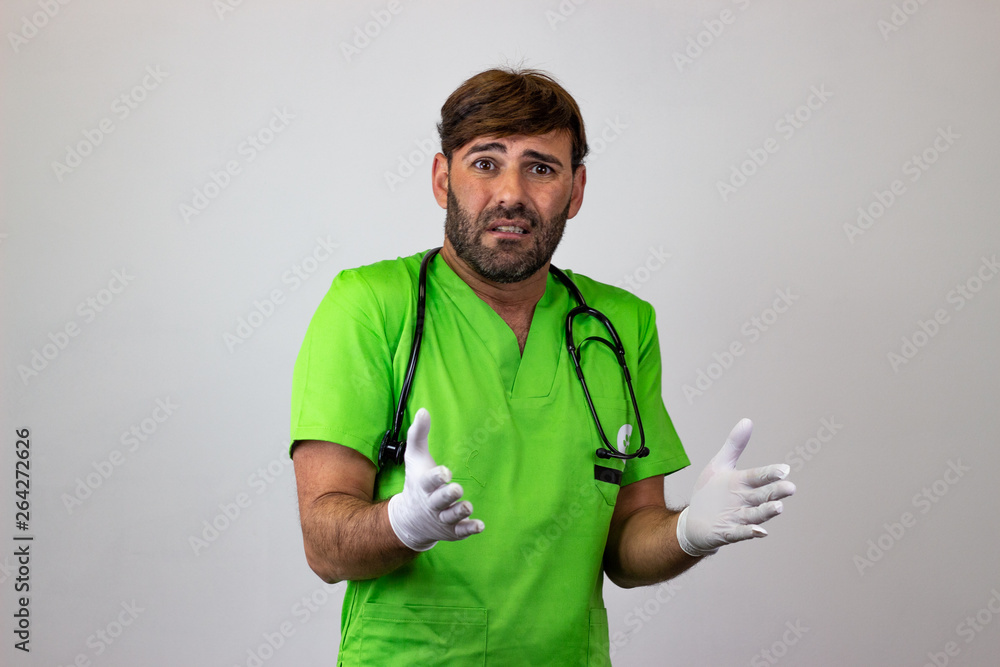 Portrait of male veterinary doctor in green uniform with brown hair embarrased, their back facing the camera and looking at the camera. Isolated on white background.
