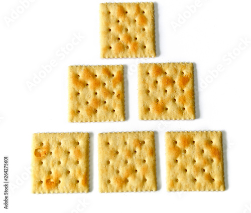 Six saltine crackers also known as soda and soup crackers on white, lined up in rows of one, two, and three as an educational counting concept. photo