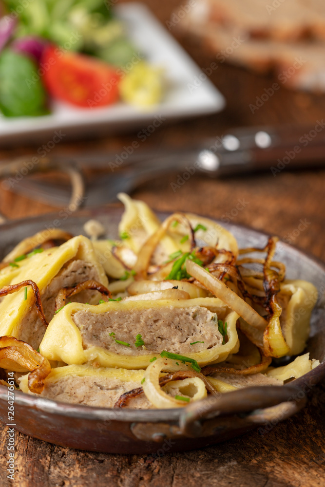 schwäbische Maultasche mit Zwiebeln in einer Pfanne schwäbische Maultasche mit Zwiebeln in einer Pfanne