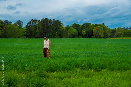 Asian woman in field surrounded by grass © David