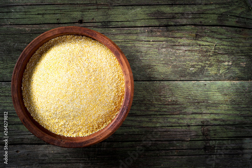 Maize meal and ceramic bowl on wooden table