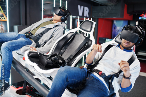 Two young indian people having fun with a new technology of a vr headset at virtual reality simulator. © AS Photo Family