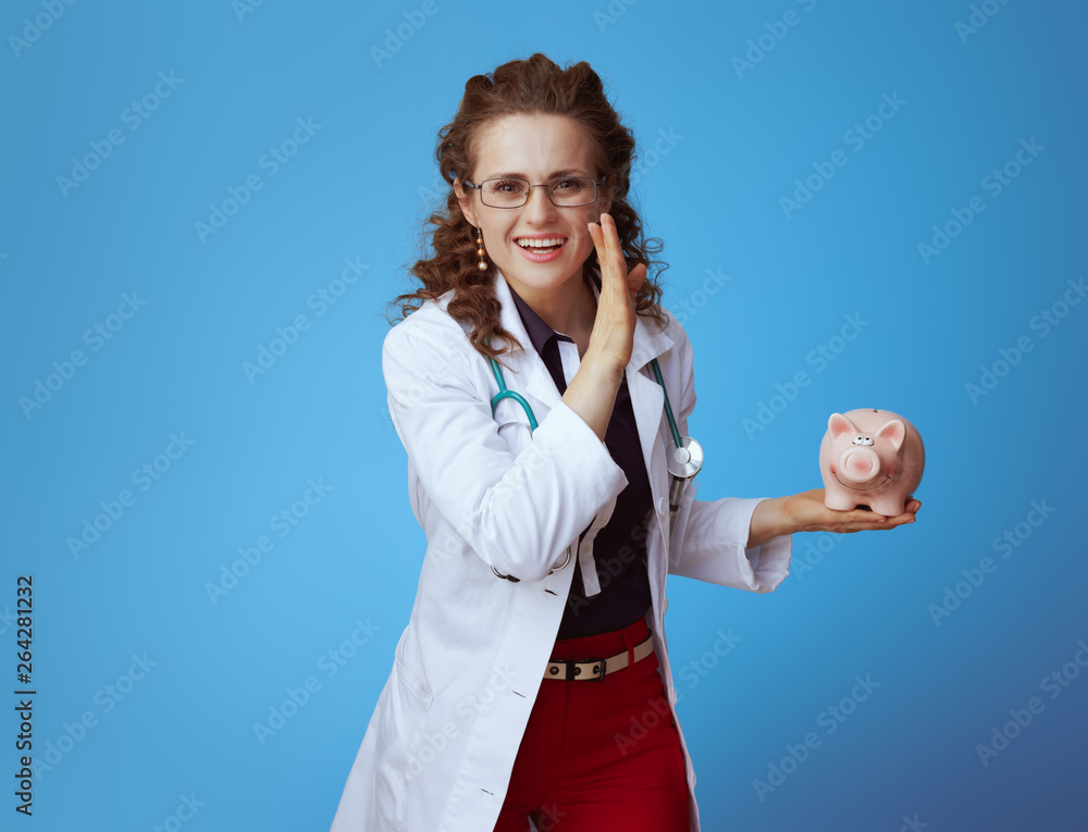 medical doctor woman with piggy bank telling exciting news medical doctor woman with piggy bank telling exciting news