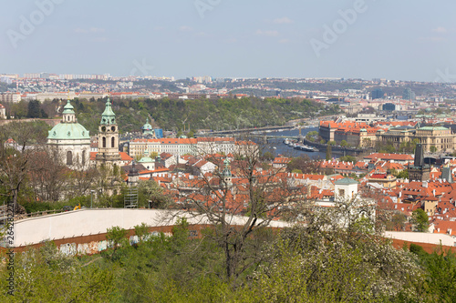 Spring Prague City with St. Nicholas' Cathedral and the green Nature and flowering Trees, Czech Republic
