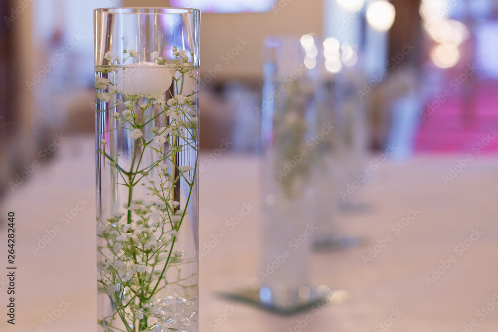 lily of the valley in water in transparent vase. restaurant hall
