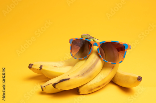 Bild auf Leinwand bananas and sunglasses on a yellow background