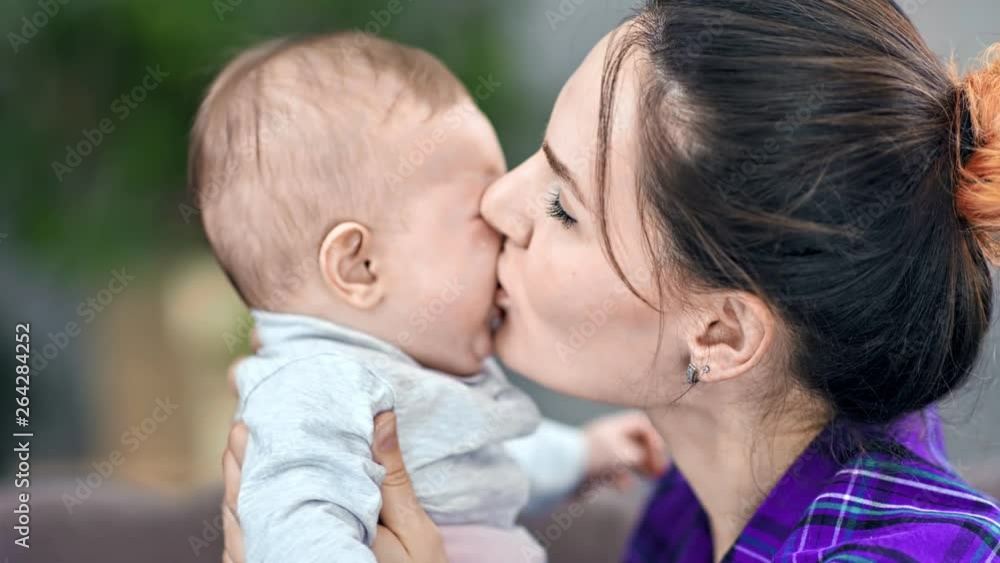 Close-up caring young mother kissing and calm down crying little cute child Close-up caring young mother kissing and calm down crying little cute child