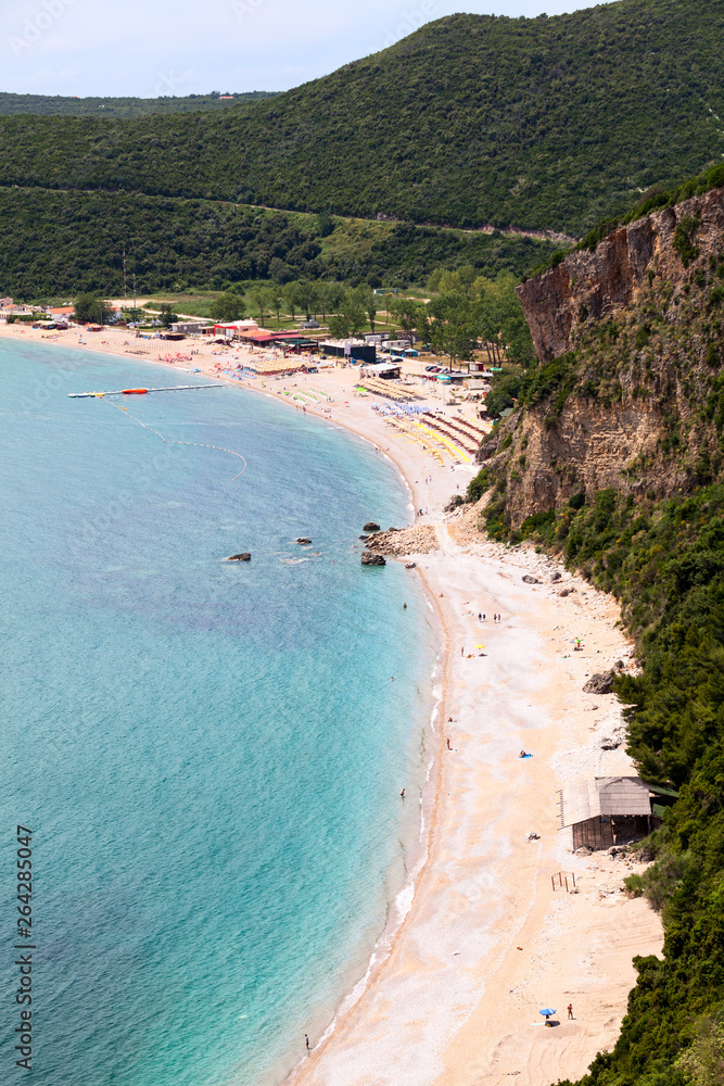 Coastline with Jaz beach in Budva municipality in Montenegro. Parasols with sun beds are on Adriatic sea shore