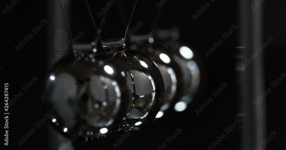 Transmission of Kinetic Energy. Loop. Steel shiny balls suspended on a ...