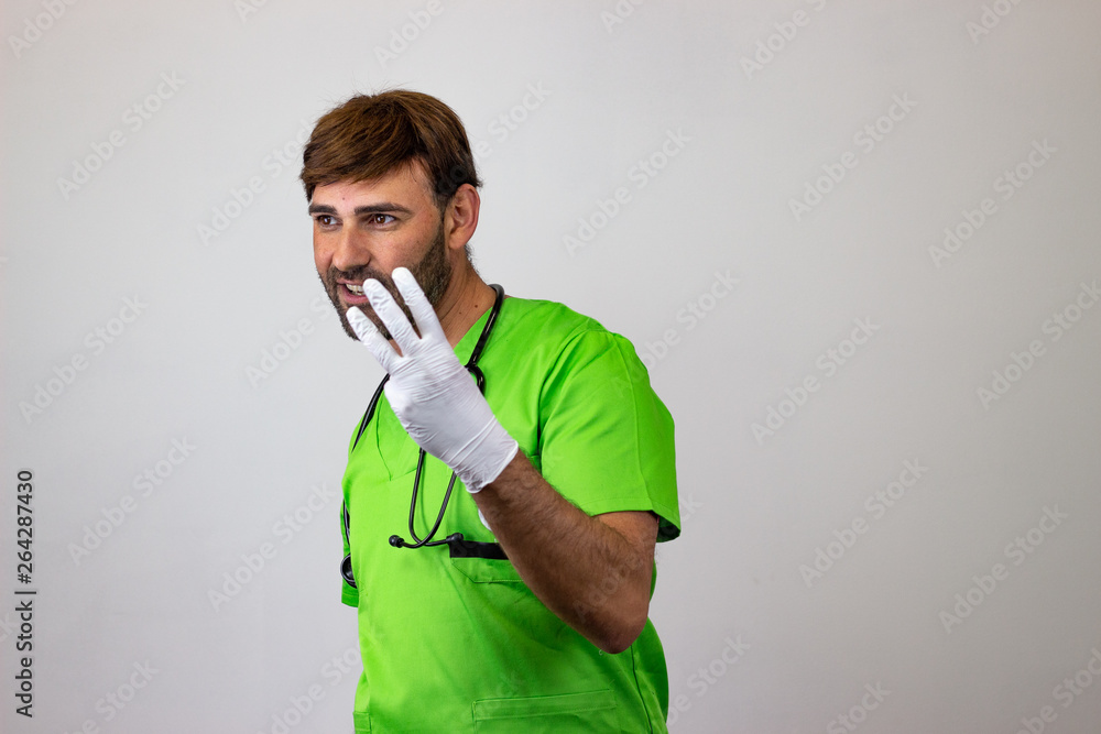 Portrait of male veterinary doctor in green uniform with brown hair holding up three fingers, facing forwards and looking at the horizon. Isolated on white background. Portrait of male veterinary doctor in green uniform with brown hair holding up three fingers, facing forwards and looking at the horizon. Isolated on white background.
