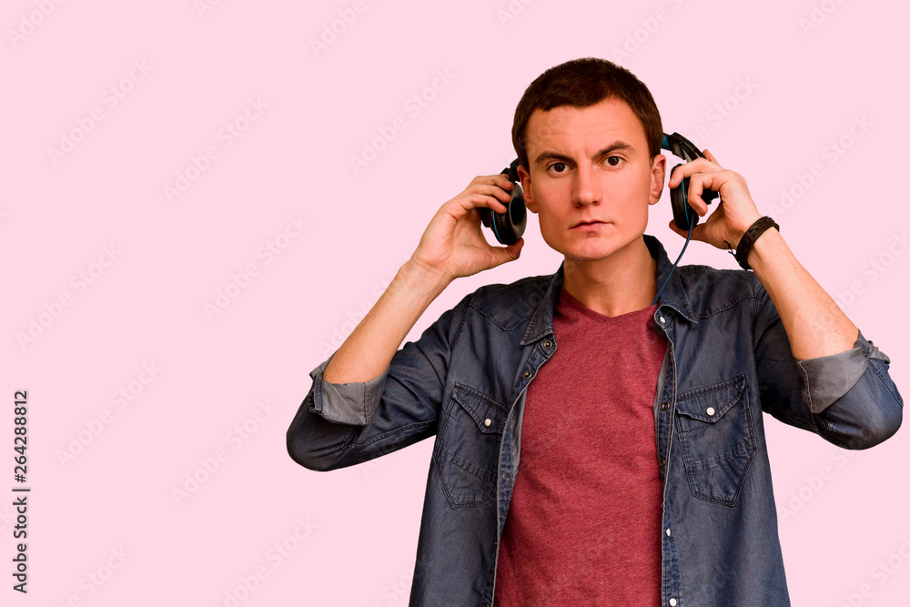 Young guy takes off his headphones. Young guy takes off his headphones.