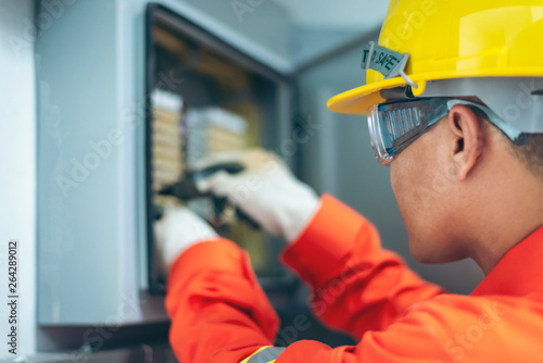 Tableau sur toile close up men working with the control cabinet