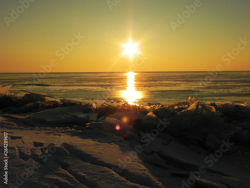 Sunset on the sea in the ice. The sun goes down and illuminates the icy sea, frosty and Sunny, details and close-up.