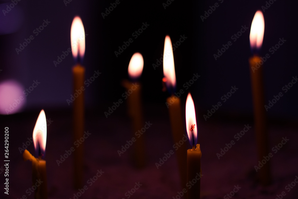 soft focus church candles yellow fire illumination in dark environment soft focus church candles yellow fire illumination in dark environment