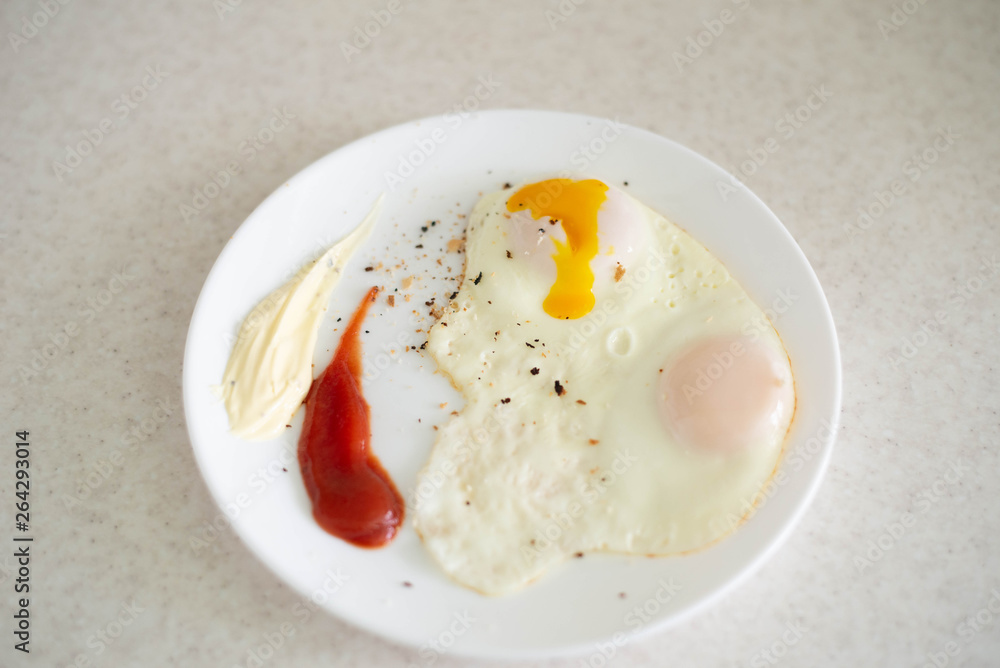 Breakfast in the form of egg with sauces on a white plate Breakfast in the form of egg with sauces on a white plate