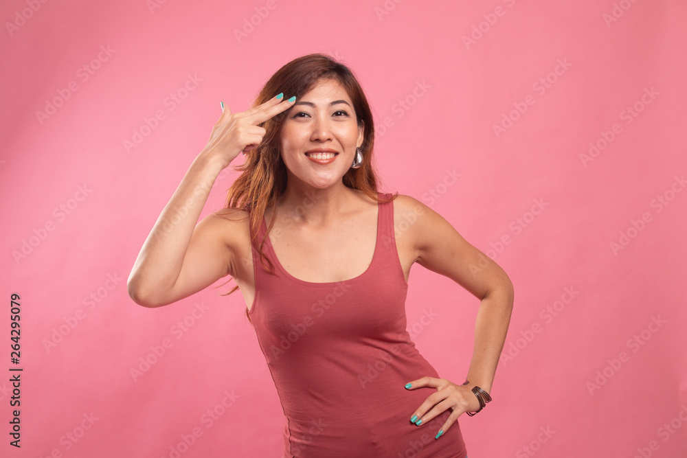 Beautiful young Asian woman holding fingers in gun gesture. Beautiful young Asian woman holding fingers in gun gesture.