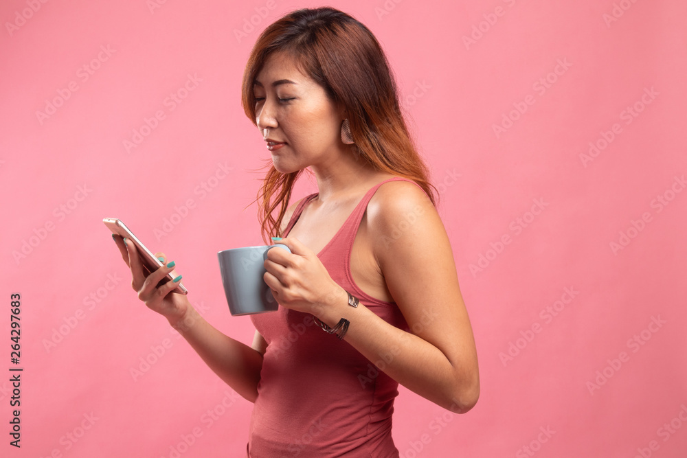 Young Asian woman with mobile phone and coffee cup. Young Asian woman with mobile phone and coffee cup.