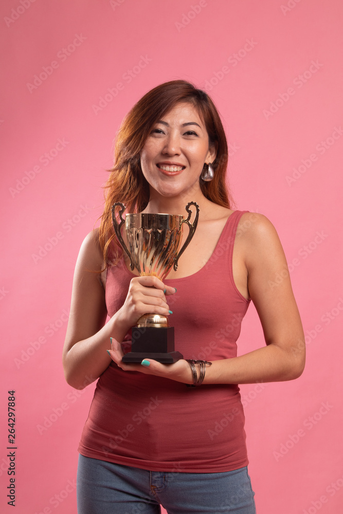 Successful young asian woman holding a trophy. Successful young asian woman holding a trophy.