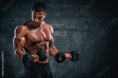 Bodybuilder Exercise With Dumbbells. Performing Dumbbell Curls for biceps © mrbigphoto