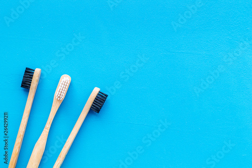 bamboo dental cleaning brush for zero waste lifestyle concept on blue background top view mock up