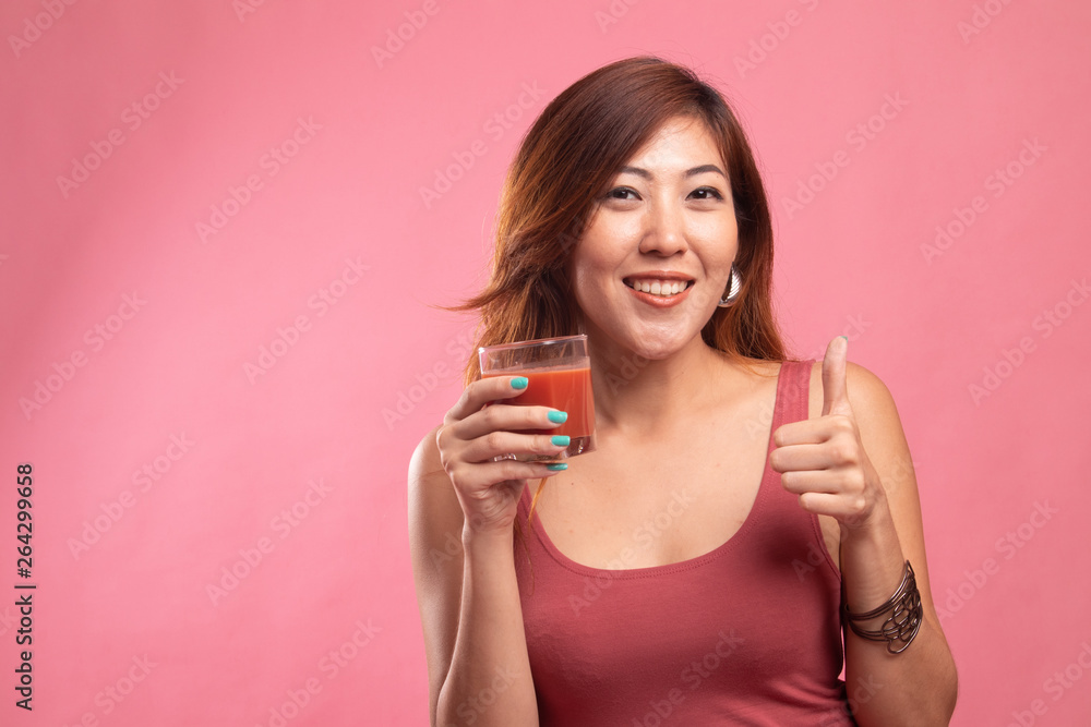 Young Asian woman thumbs up with tomato juice. Young Asian woman thumbs up with tomato juice.