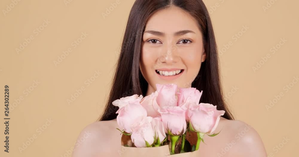 Portrait of beautiful asian woman looking to camera with attractive smile. Beautiful asian woman holding lily in hand with happy emotion. People with beauty and skin care concept. Portrait of beautiful asian woman looking to camera with attractive smile. Beautiful asian woman holding lily in hand with happy emotion. People with beauty and skin care concept.