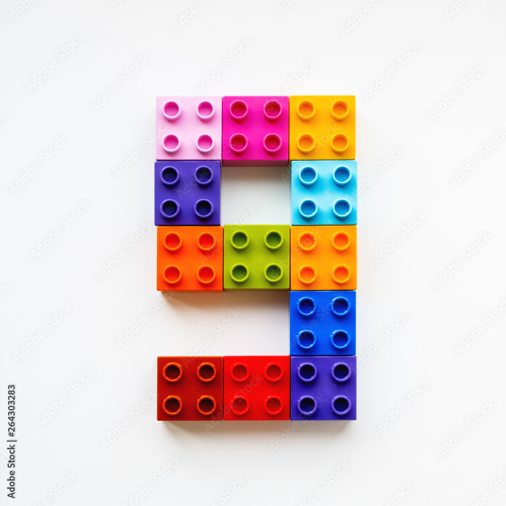 Fototapeta premium Number Nine made of colorful constructor blocks. Toy bricks lying in order, making number 9. Education process - learning numbers with child using multicolored toy details.