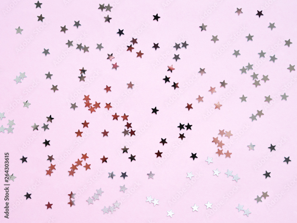 Holiday background with silver star confetti on pink background. Good backdrop for Christmas and New Year cards. Flat lay, top view. Holiday background with silver star confetti on pink background. Good backdrop for Christmas and New Year cards. Flat lay, top view.