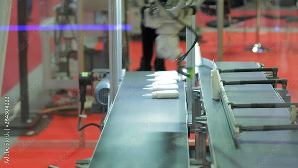 Robot arm sorting out steel components from a conveyor belt Robot arm sorting out steel components from a conveyor belt