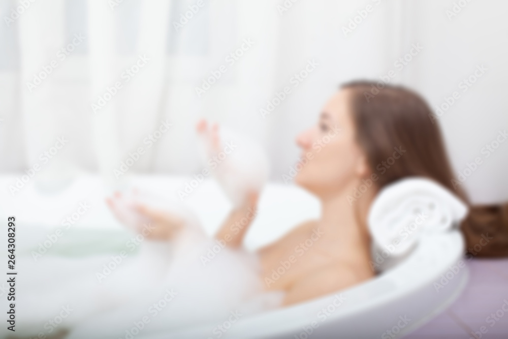 Young pretty woman relaxes in bathtube with soap foam. Spa procedures in bathroom at home or hotelroom. Skin care and moisturizing for youth preservation. Young pretty woman relaxes in bathtube with soap foam. Spa procedures in bathroom at home or hotelroom. Skin care and moisturizing for youth preservation.