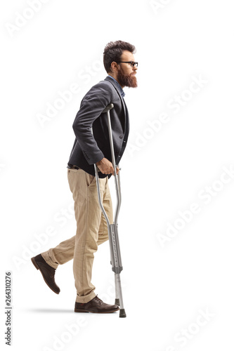 Stampa su tela Young bearded man walking with crutches
