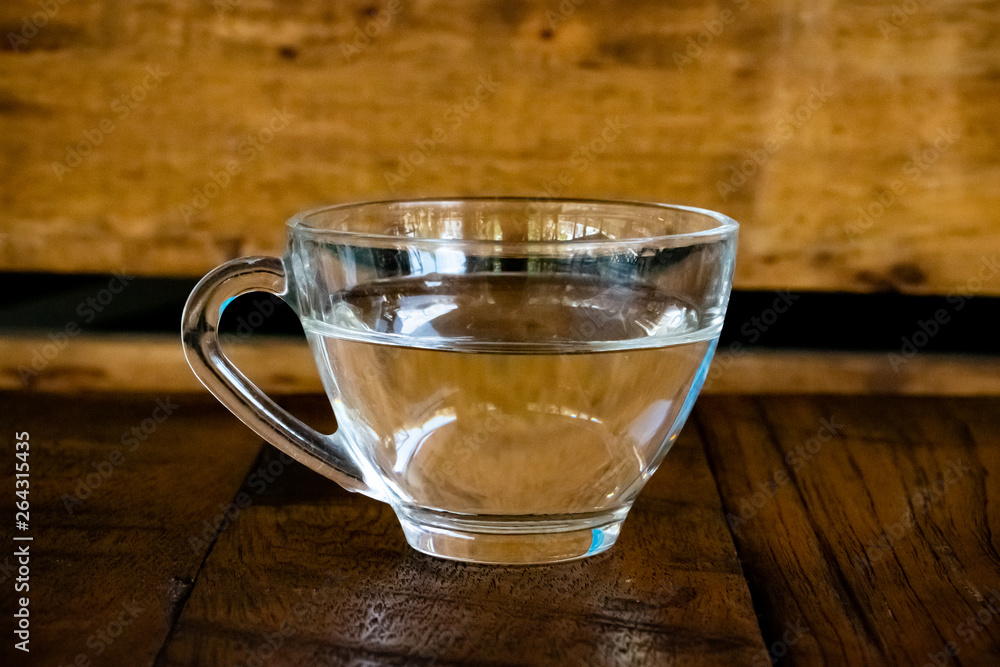 The isolated photo of a cup of clear water on wooden background. The isolated photo of a cup of clear water on wooden background.