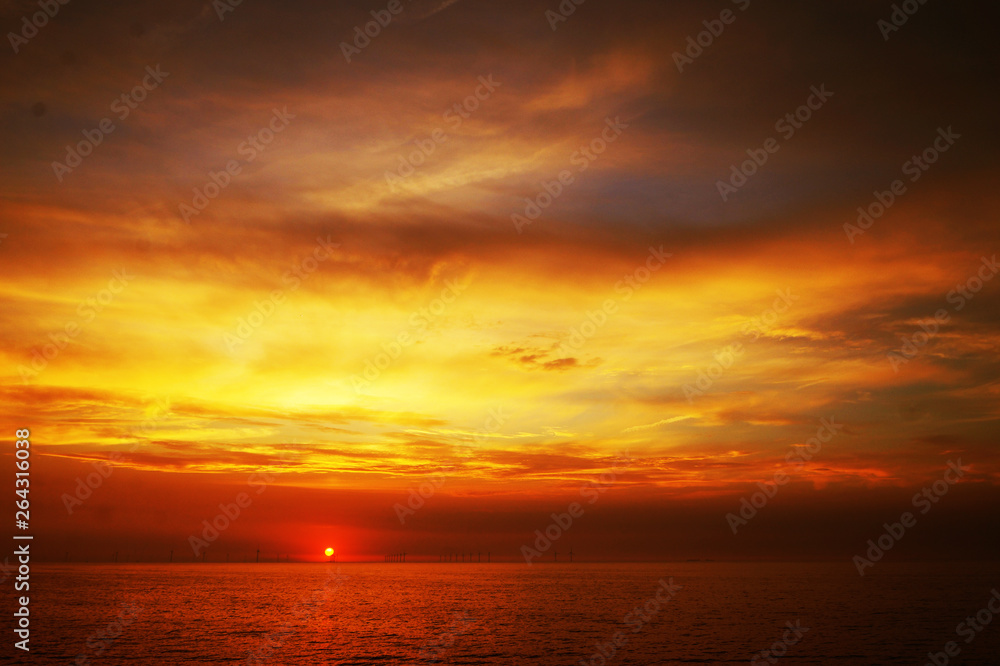 Rich golden and orange coastal sunset with detailed cloud and the open sea. United Kingdom Rich golden and orange coastal sunset with detailed cloud and the open sea. United Kingdom