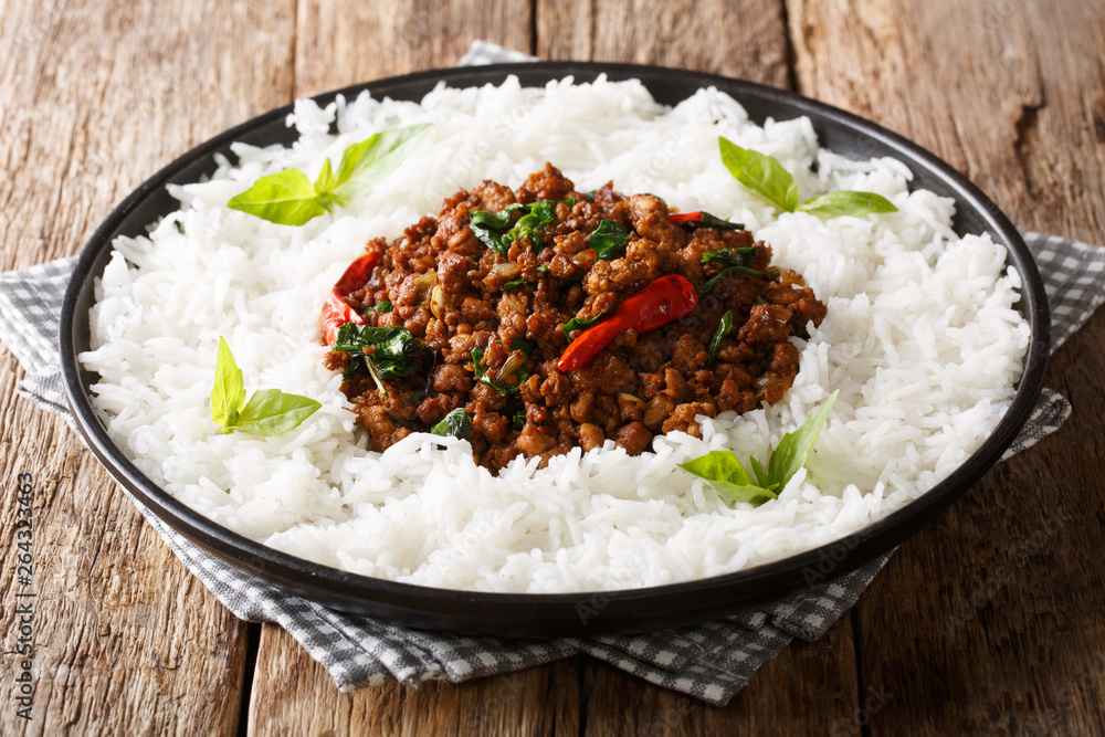 Traditional basil chicken with chili pepper and soy sauce with rice garnish close-up on a plate. horizontal Traditional basil chicken with chili pepper and soy sauce with rice garnish close-up on a plate. horizontal
