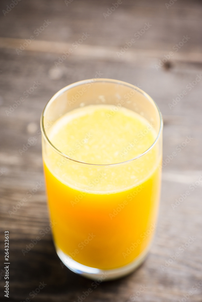 Fresh squeezed orange juice on the rustic background. Selective focus. Shallow depth of field. 