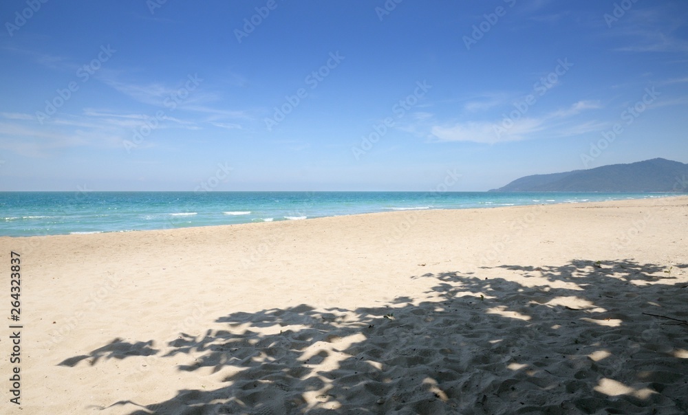 Empty tropical sandy beach, blue sky, shadow of the tree, Na Dan Beach in Khanom district of Nakhon Si Thammarat province of Thailand.