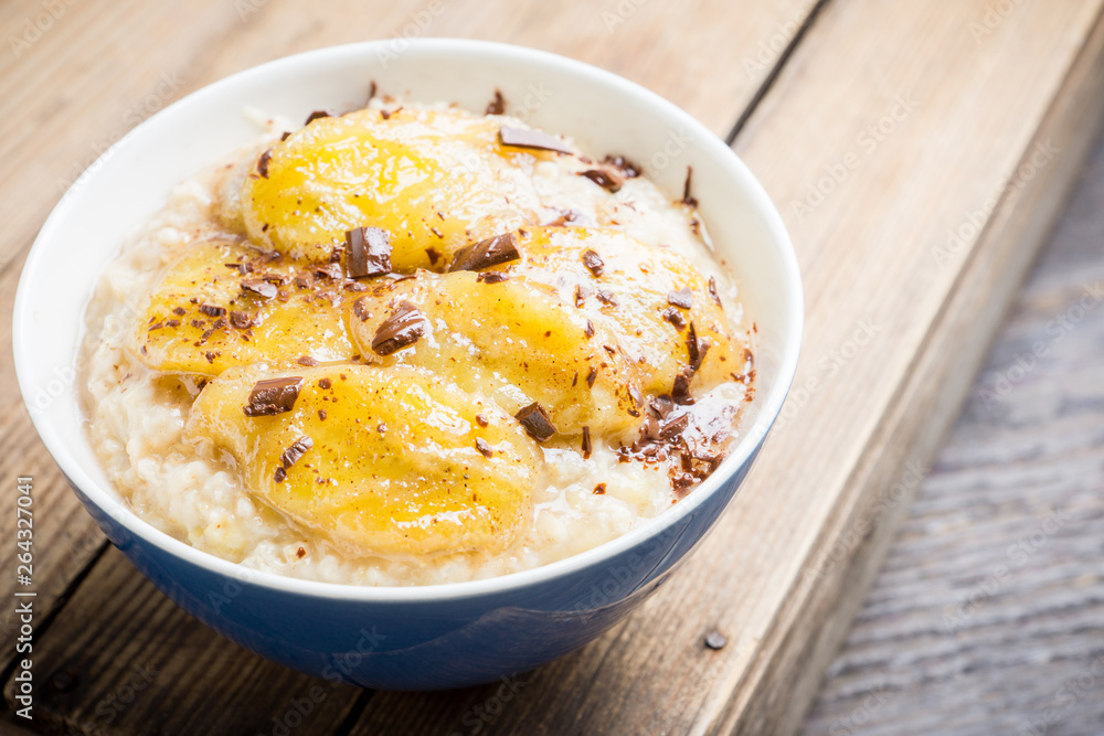 Oatmeal with roasted bananas and chocolate. Selective focus. Shallow depth of field.