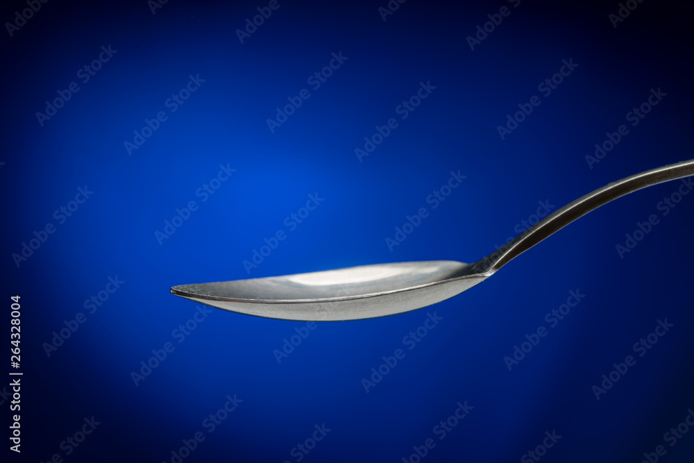 tablespoon on blue background closeup tablespoon on blue background closeup