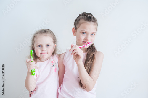 Two Cute pretty little child brushing teeth