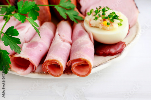 Plate with sliced ham and stuffed eggs.