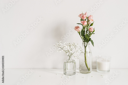 Roses  gypsophila and candle on table wall background. Romantic mockup template. Elegant minimalist