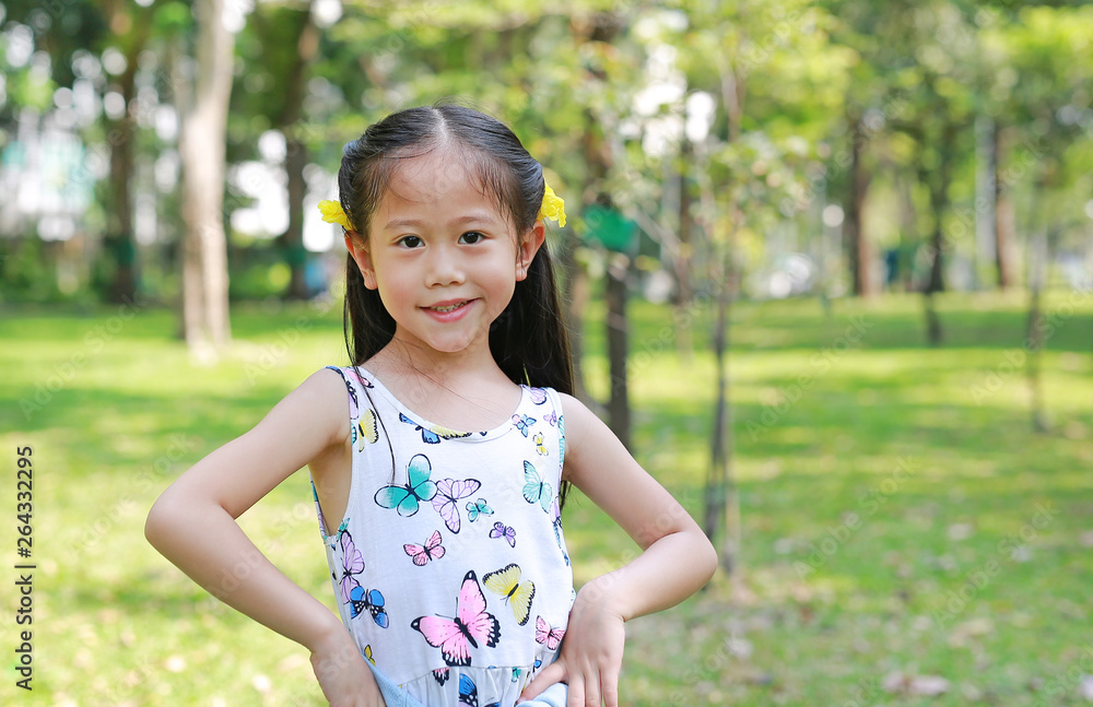Portrait of happy little Asian child girl with yellow flower on ears in summer garden outdoor. Portrait of happy little Asian child girl with yellow flower on ears in summer garden outdoor.
