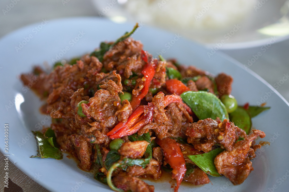 Spicy fried deer Thailand food on blue plate Spicy fried deer Thailand food on blue plate