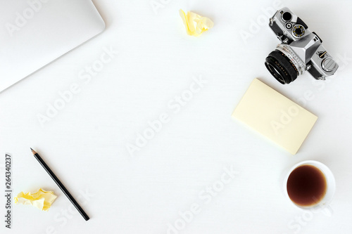 Creative flat lay photo of workspace desk with laptop, coffee  blank paper and film camera background