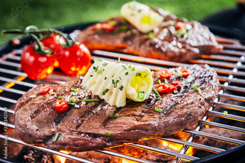 Foto Succulent piece of rump steak grilling on a BBQ
