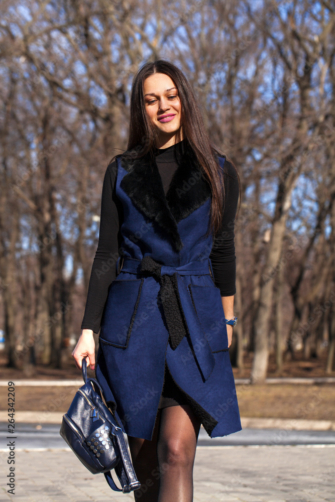Portrait of a young beautiful woman in blue coat walking in spring park Portrait of a young beautiful woman in blue coat walking in spring park