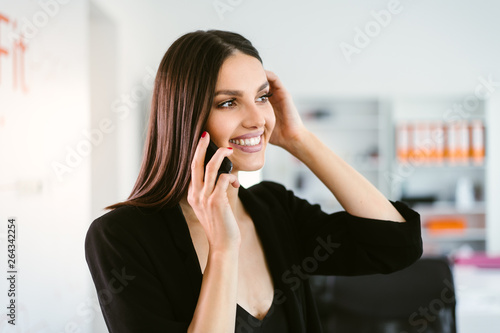 Manager on her phone. Female boss using her phone at the office. Employee on the phone.