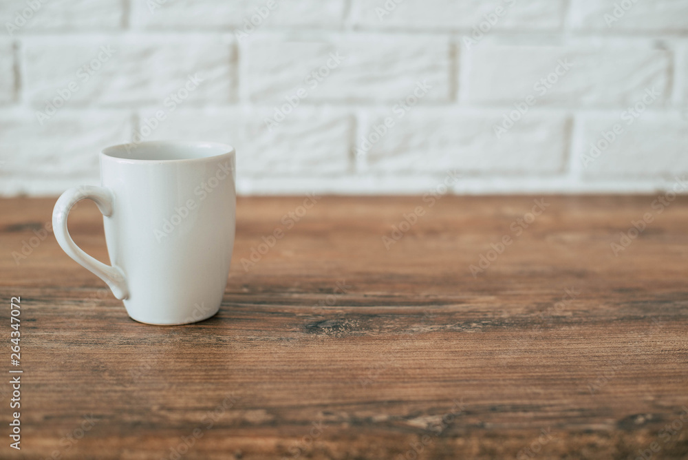 White cup on a wooden table White cup on a wooden table